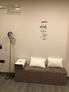 奥维多Madala XXI的一个带两个枕头的沙发,位于带灯的房间