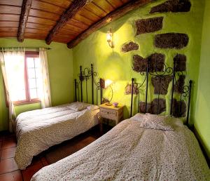 Las RosasGeranios Rojos II的一间卧室设有两张床和石墙
