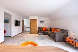 威廉堡Tower Ridge Courtyard的客厅配有灰色沙发和橙色枕头。