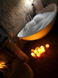 圣斯特凡诺·迪塞斯西克斯坦堤欧艾尔伯格迪富索酒店的浴室配有云雾和蜡烛浴缸。