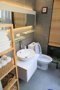九份木质元素的浴室配有白色水槽和卫生间。
