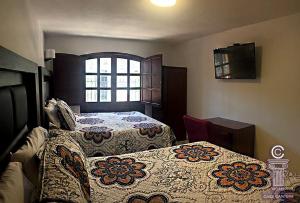 莱昂Hotel Casa Cantera的一间卧室设有两张床和窗户。
