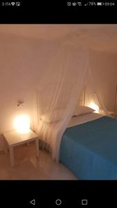 莫诺波利Casa Vacanza La Conchiglia的一张带天蓬的床和一张带灯的桌子