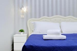 罗马Domus Domas - Golden Keys Collection的一间卧室配有一张蓝色的床和白色床头板