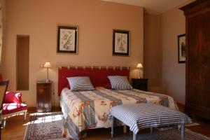 多尔多尼河畔博利厄格勒泽城堡酒店的一间卧室配有一张红色床头板的床