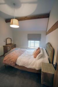 AstburyHoneysuckle Cottage, Drift House Holiday Cottages的一间卧室设有一张大床和一个窗户。