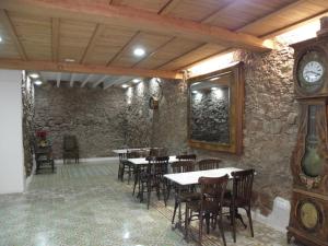 Sant Llorenc Savall卡尔普拉旅馆的一间带桌椅和时钟的餐厅