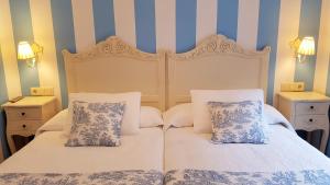 拉瓜迪亚Legado de Ugarte, Casa Rural的卧室内的两张床,带蓝色和白色条纹