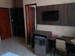 波多韦柳中央酒店的一间房间,配有一张桌子和一台墙上的电视