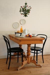 莱比锡SCHÖNER WOHNEN IM DENKMAL - großzügig geschnitten, kostenfreies WLAN的一张桌子,上面有两把椅子和一碗水果
