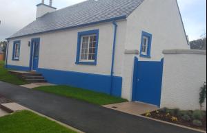 因弗内斯Olavat Cottage detached property with parking的蓝色和白色的房子,有蓝色的门