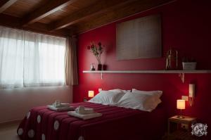 孔韦尔萨诺Gli Amanti del Sogno的红色卧室,配有带毛巾的床