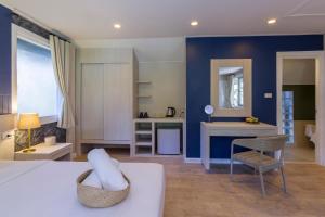 北芭堤雅Let's Hyde Pattaya Resort & Villas - Pool Cabanas的一间卧室配有一张床、一张桌子和一把椅子