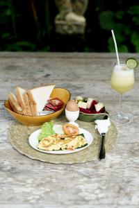 乌布巴厘岛幻想假日公园的一张桌子,上面放着一盘食物和一杯果汁