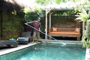 乌布巴厘岛幻想假日公园的持水管在游泳池旁的人