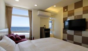 绿岛綠島 綠堤濱海旅店的一间卧室配有一张床和一台平面电视