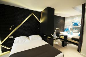 巴黎凯旋门之星酒店的一间卧室设有一张床和黑色的墙壁
