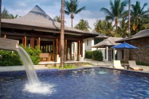 蔻立Khaolak Blue Lagoon Resort - SHA Extra Plus的一座房子前面带喷泉的游泳池