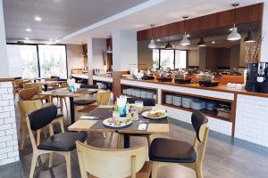 清迈Hotel MAYU Chiang Mai的一间带桌椅的餐厅和一间厨房