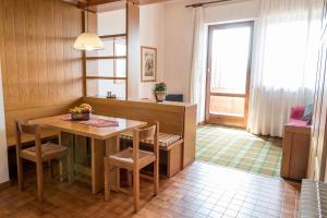 阿夏戈阿尔卑斯公寓式酒店的厨房配有桌椅和窗户。