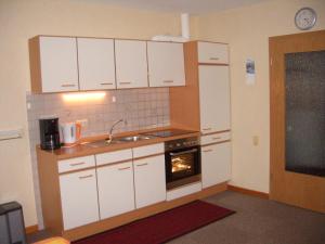 纽哈灵吉塞尔Haus Delphin的厨房配有白色橱柜、水槽和烤箱。