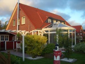 纽哈灵吉塞尔Haus Delphin的一座有红色屋顶和红色消防栓的房子