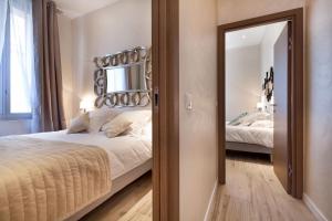 戛纳卢浮宫公寓 - LRA戛纳的一间卧室配有一张大床和镜子