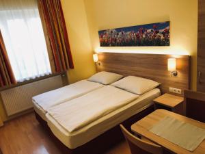 萨尔茨堡萨尔兹堡酒店的一间小卧室,配有一张床和一张桌子