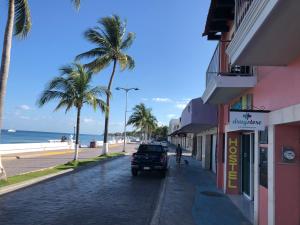 科苏梅尔Hostel Tropico 20º的沿着海滩旁的街道行驶的汽车