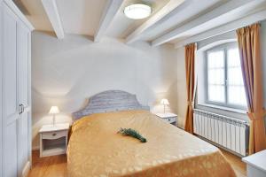 莫托文Casa Meloni的一间卧室配有一张带两张桌子和两个窗户的床。