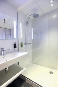 雷恩安娜酒店的带淋浴和盥洗盆的白色浴室