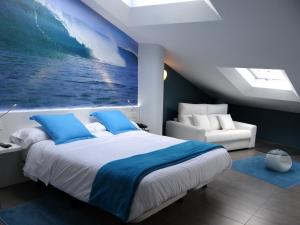 Ea贝卡莱酒店的卧室配有一张大床,墙上挂有绘画作品