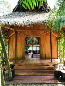 马尔多纳多港Casa Amazonas的竹制建筑,带茅草屋顶和走廊