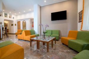索伦托旅游酒店的一间设有绿色和橙色椅子和桌子的等候室