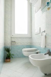 里米尼卡德特酒店的一间带卫生间、水槽和窗户的浴室