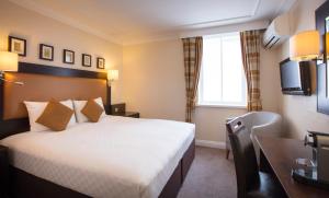 希灵登伦敦希思罗机场5号航站楼提斯特尔酒店的配有一张床和一张书桌的酒店客房