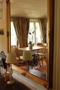 BrionLe Logis du Pressoir Chambre d'Hotes Bed & Breakfast in beautiful 18th Century Estate in the heart of the Loire Valley with heated pool and extensive grounds的饭厅镜子,前面有一张桌子