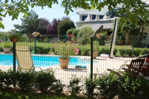BrionLe Logis du Pressoir Chambre d'Hotes Bed & Breakfast in beautiful 18th Century Estate in the heart of the Loire Valley with heated pool and extensive grounds的游泳池周围的围栏,带两把椅子