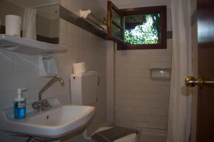 萨米斯缇格亚公寓酒店的一间带水槽和卫生间的浴室以及窗户。
