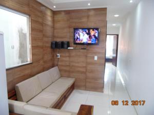 甘博阿Propriedade Silva的客厅配有沙发和墙上的电视