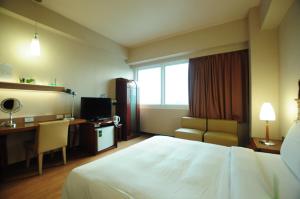 高雄康桥商旅五甲馆的酒店客房配有一张床、一张书桌和一台电视。