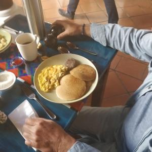 危地马拉安地瓜Casa Elena的坐在餐桌上的人,带上一盘早餐食品