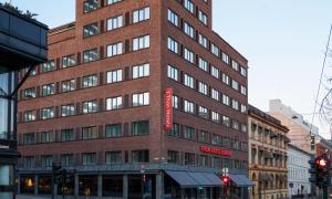 奥斯陆欧罗巴松酒店的一座高大的砖砌建筑,上面有红色的标志