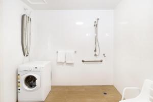 堪培拉甘加林 公寓的白色的浴室内配有洗衣机。