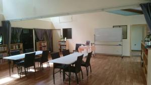 斯普林伍德Springwood Meditation Centre 春木禪修渡假中心的一个带桌椅的教室和白色板