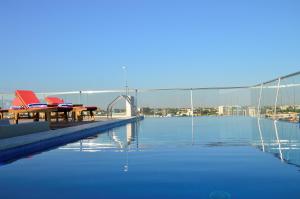罗安达帕尔梅拉斯套房酒店的一座桥上配有桌椅的游泳池