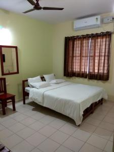 班加罗尔维加居住宾馆的一间卧室配有两张床和吊扇