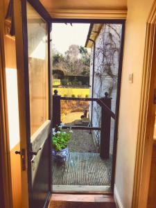 韦斯特尔顿The Apple Loft的通向门廊的敞开的门,门廊上种植了盆栽植物