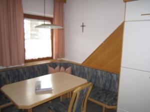 Terfens费瑞豪斯玛瑞提娜度假屋的一间设有桌子和墙壁十字架的用餐室