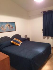 阿西亚罗利Residenza Le Serre的一间卧室配有一张蓝色的床,上面有枕头